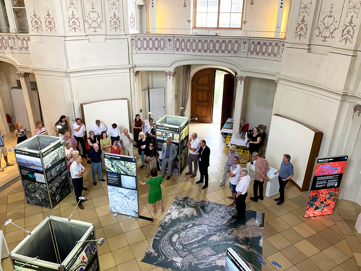 Eröffnung der Wanderausstellung "Bayern von oben" in Eichstätt Blick von oben in den Ausstellungsraum mit Touch-Bildschirmen sowie Ausstellungstafeln mit Bildern und Texten