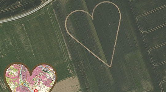 Luftbild von einem Feld auf dem ein Herz abgebildet wurde. Unten links ist ein Herzförmiger Kartenausschnitt